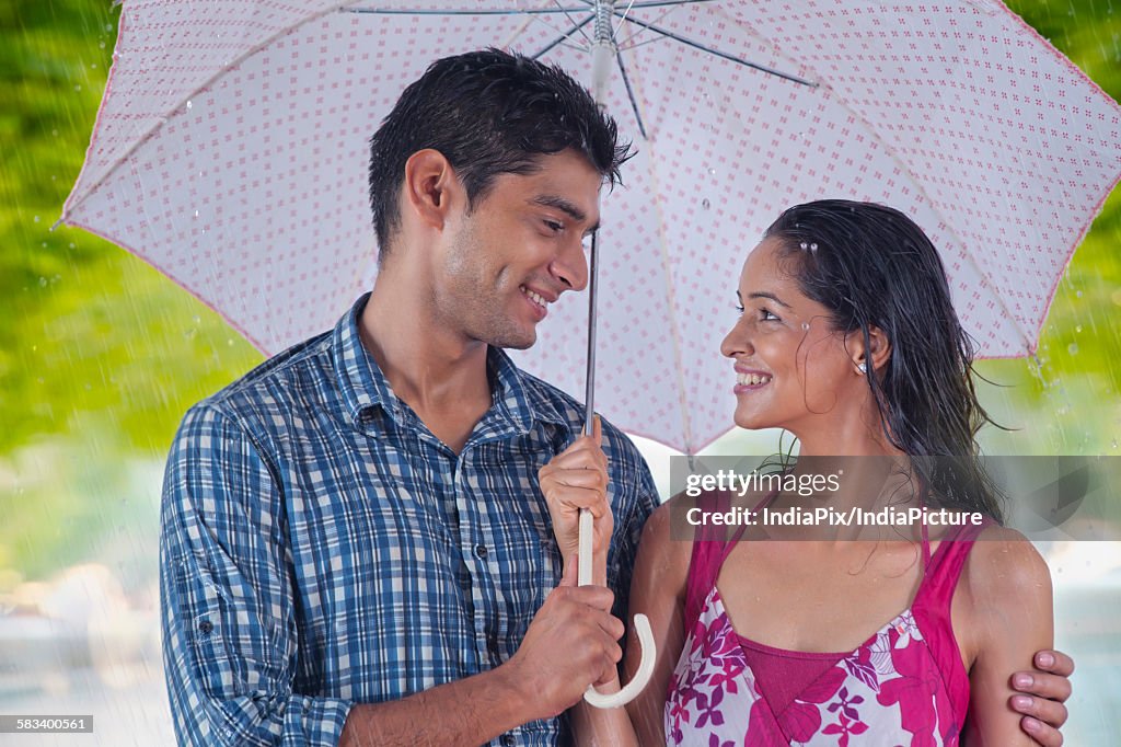 Couple with umbrella enjoying the rain