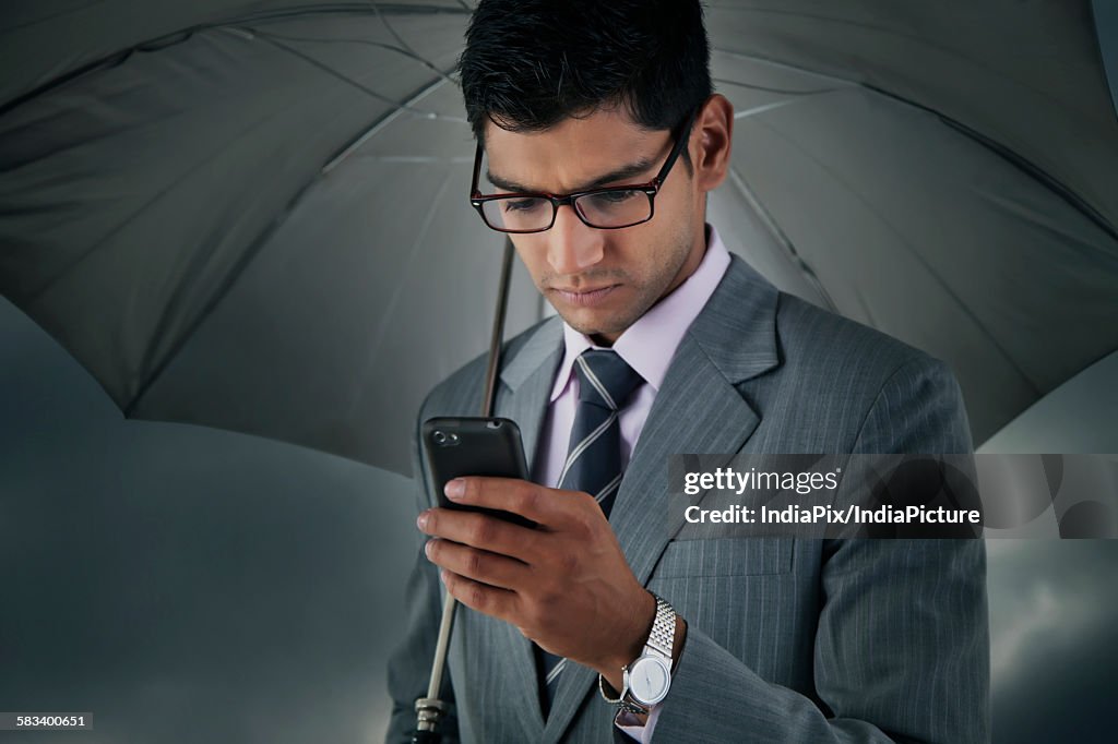 Businessman reading sms on mobile phone