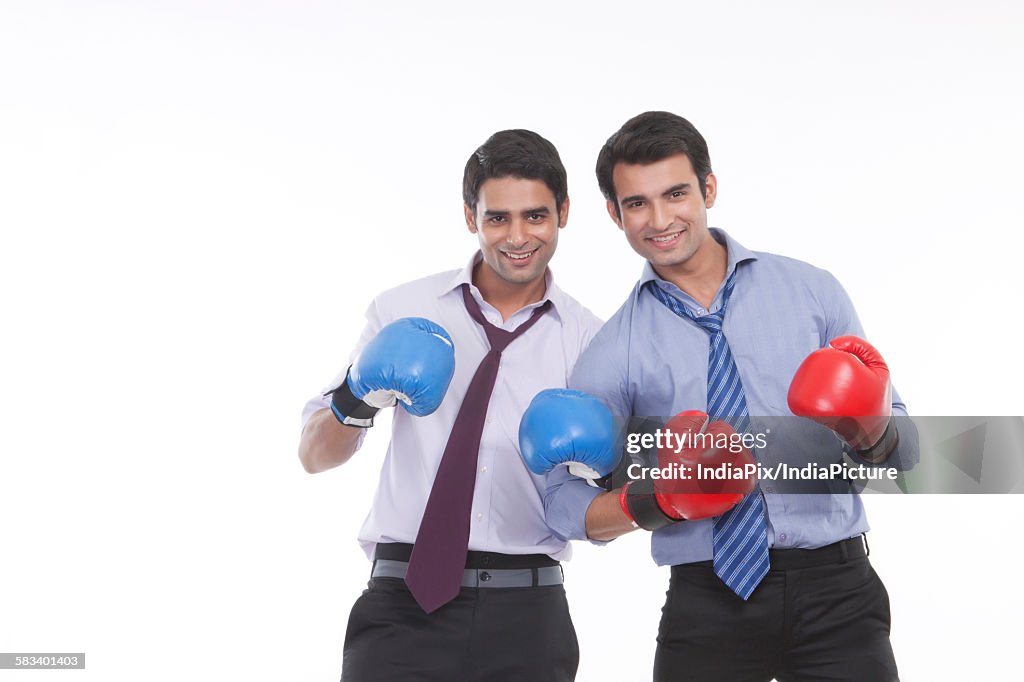 Portrait of two male executives with boxing gloves