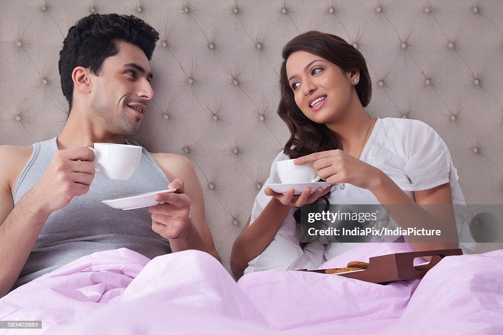 Couple having coffee in bed