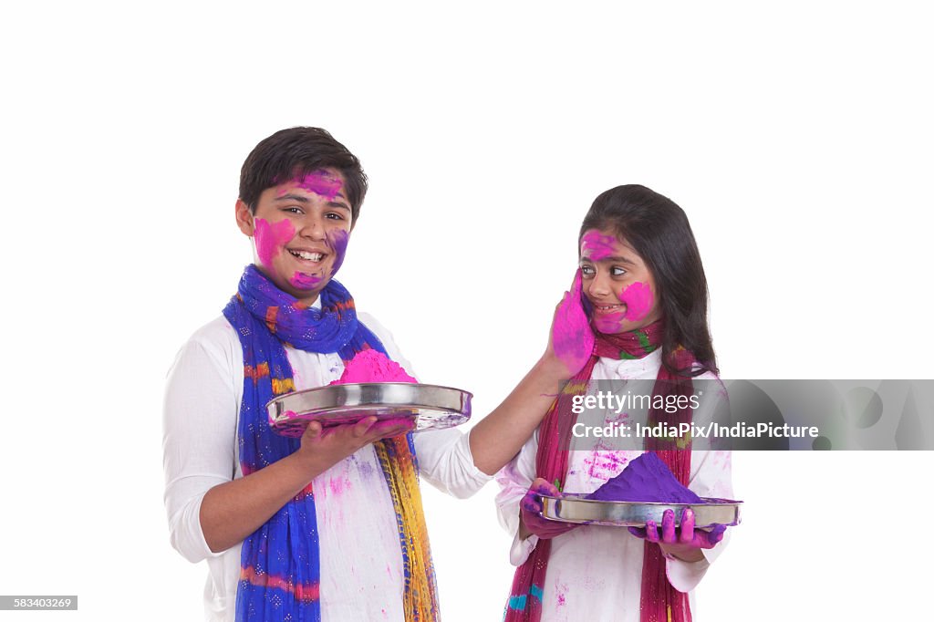 Portrait of a boy putting holi colour on a girl