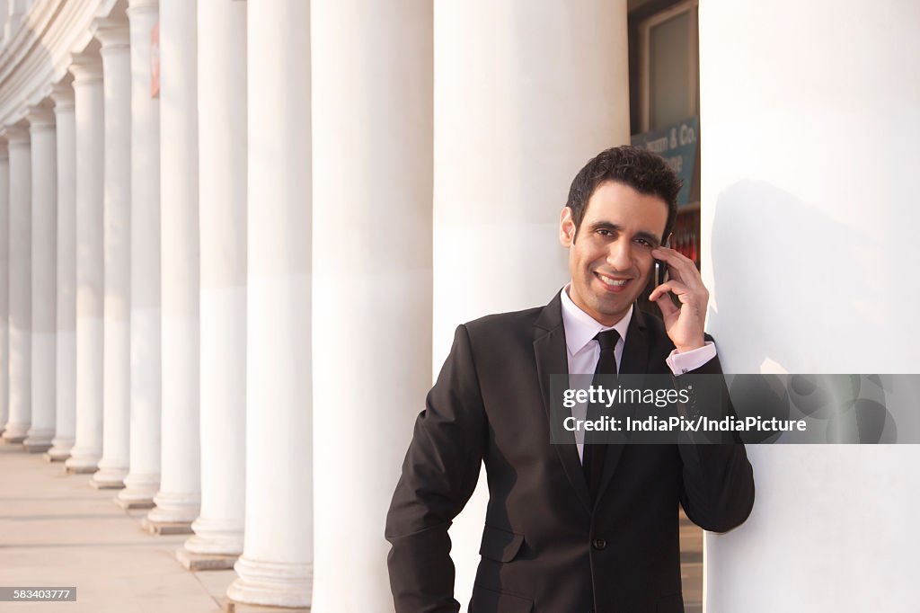 Portrait of a businessman talking on a mobile phone  , INDIA , DELHI