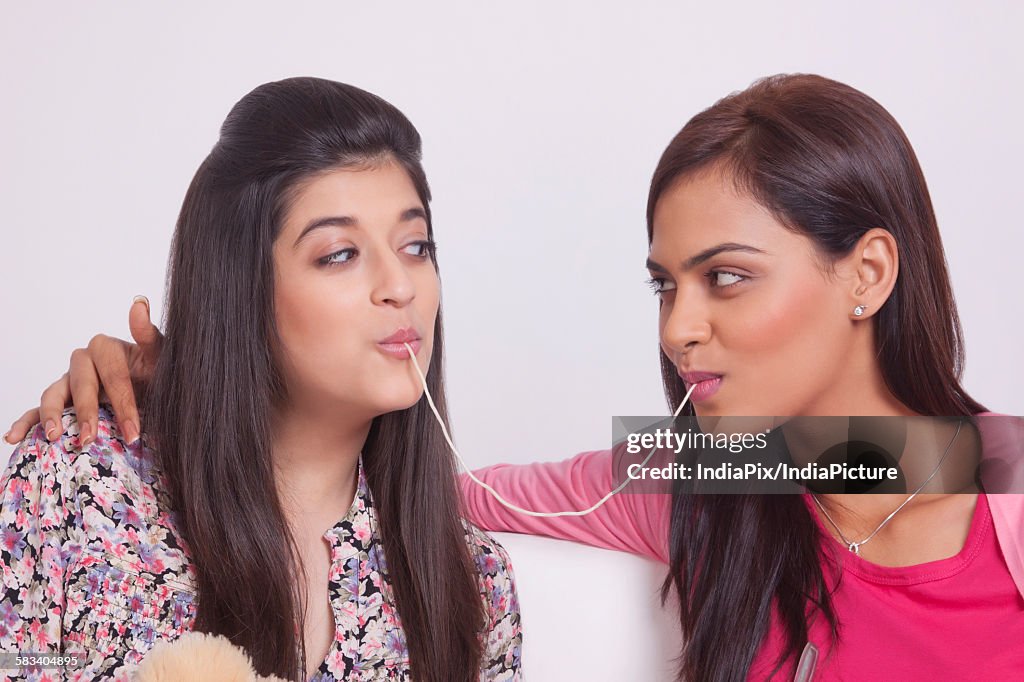 Two young women eating noodles