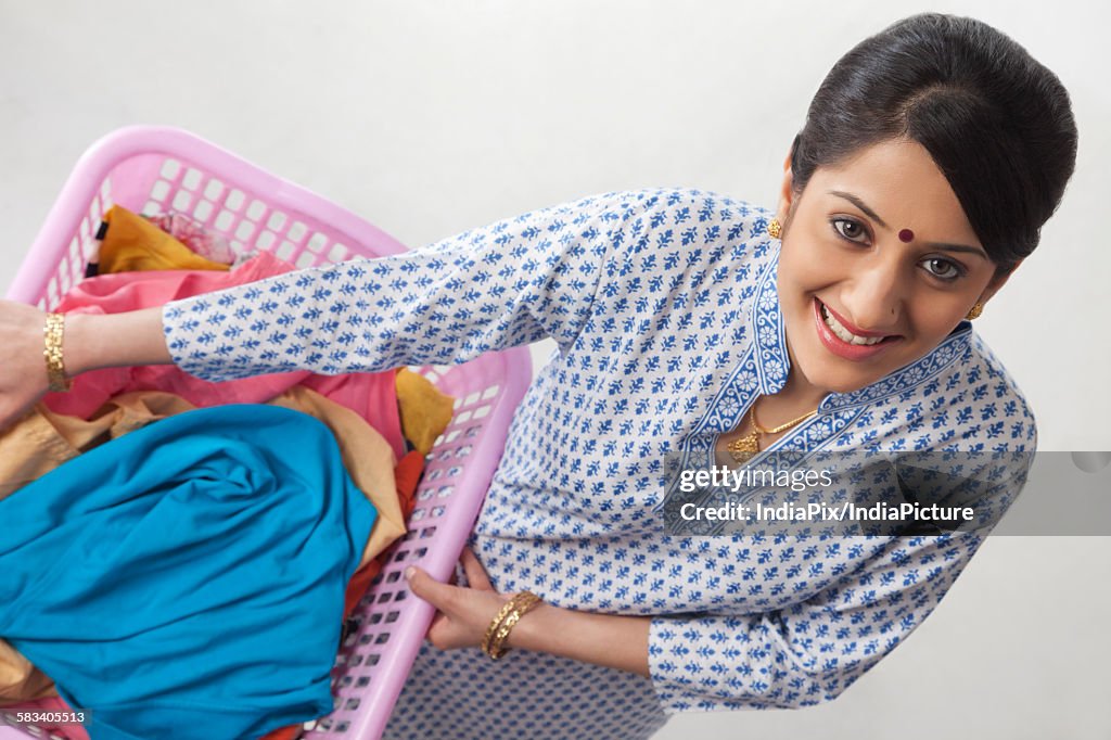 Young woman holding a basket of clothes