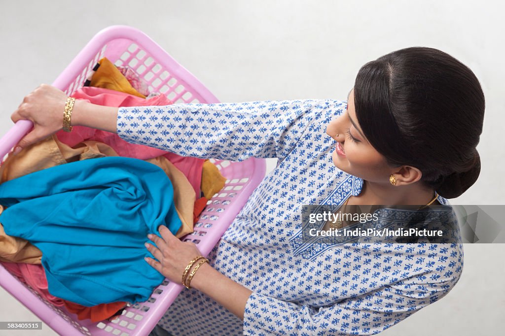 Young woman holding a basket of clothes