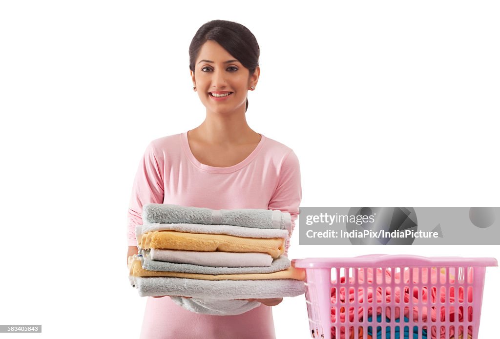 Young woman holding a pile of towels