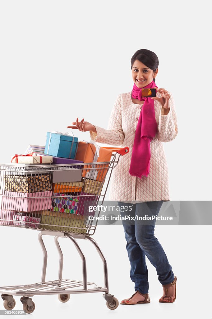 Young woman holding a cart full of gifts