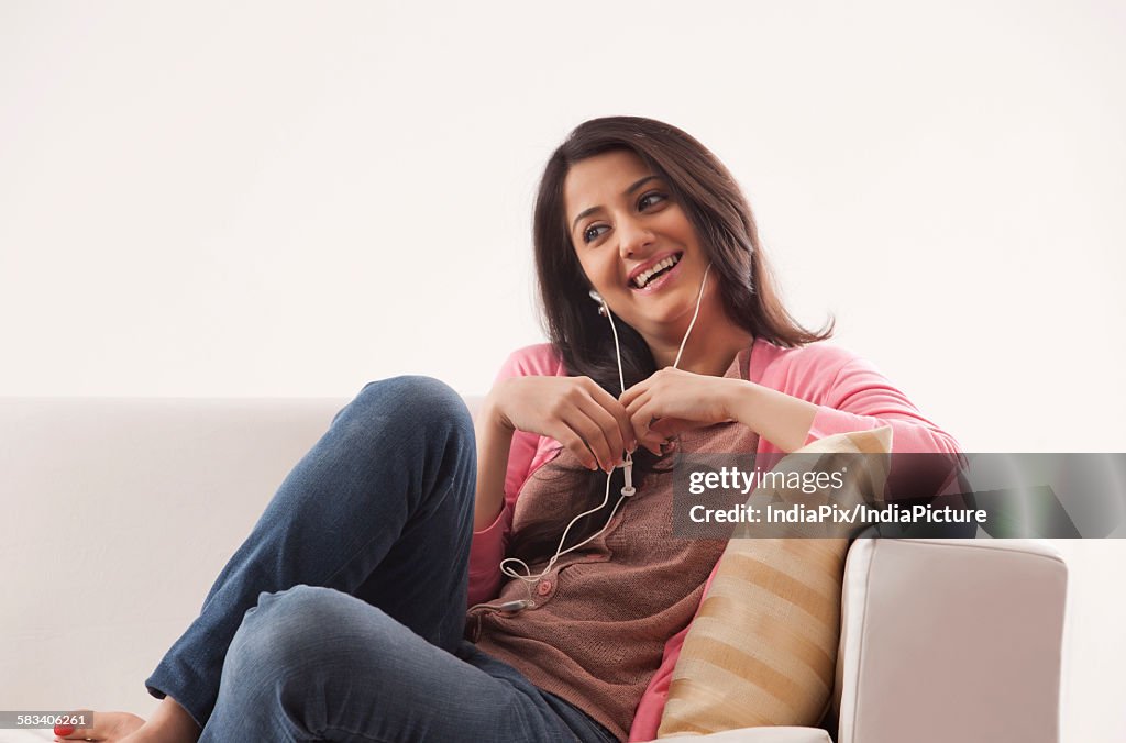 Young woman listening to music on her earphones