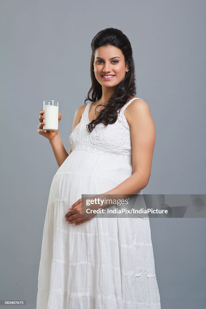 Portrait of a pregnant woman with a glass of milk