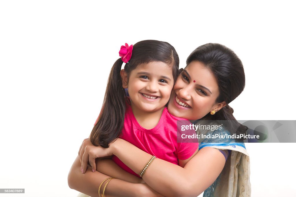 Portrait of mother hugging daughter