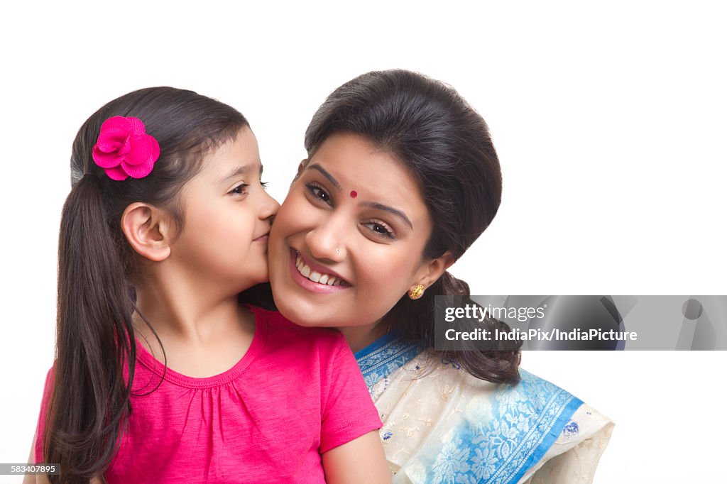 Girl kissing her mother on the cheek