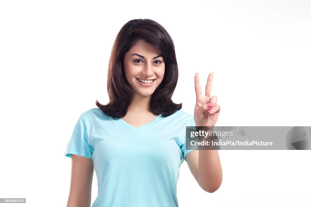 Portrait of a woman giving peace sign