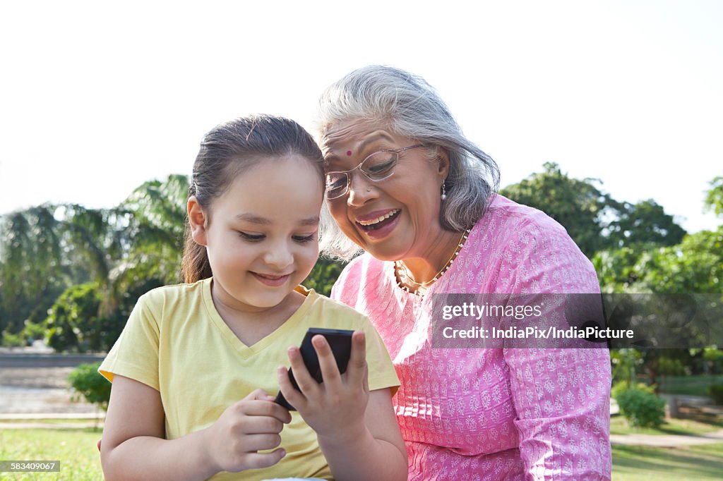 Grandmother and granddaughter reading an sms