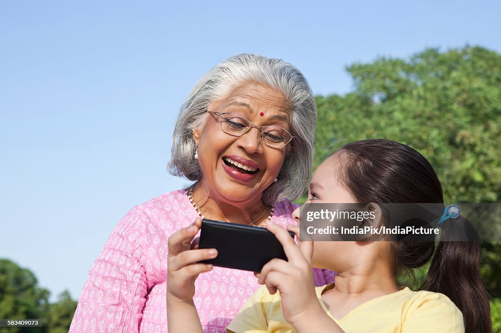 Grandmother and granddaughter with a mobile phone