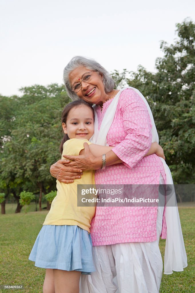 Portrait of grandmother and granddaughter hugging