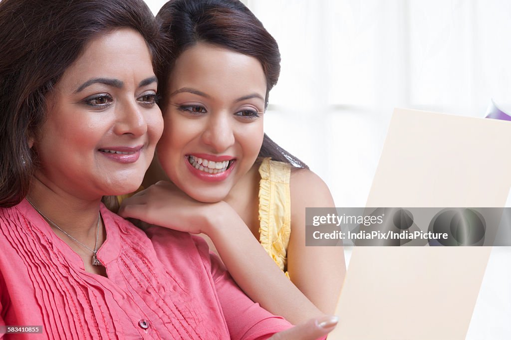 Mother reading card with daughter