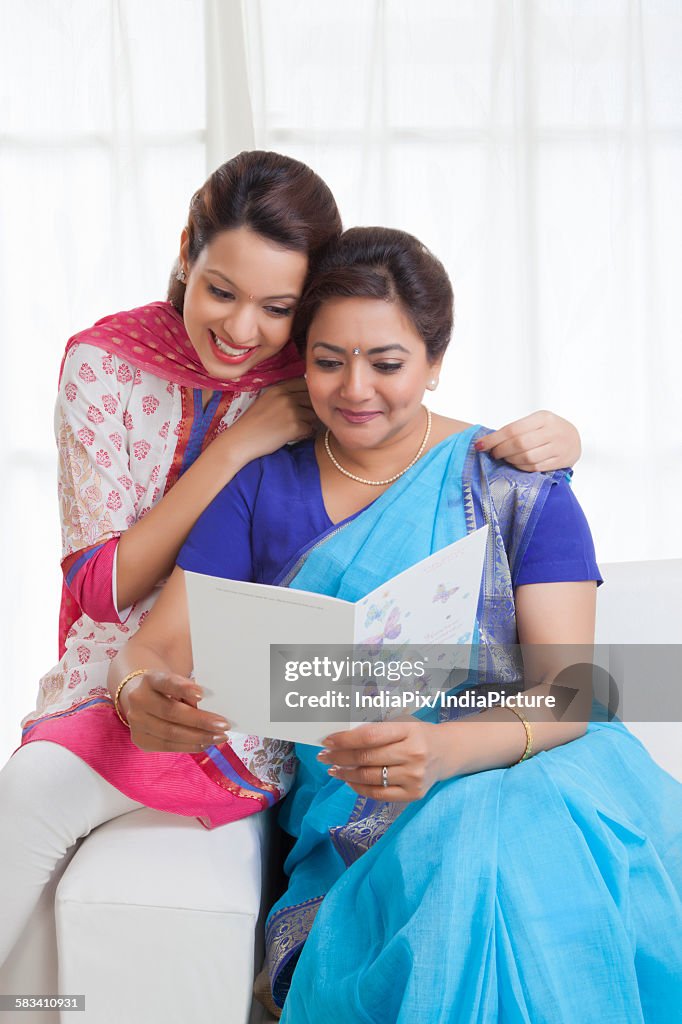 Mother and daughter reading a greeting card