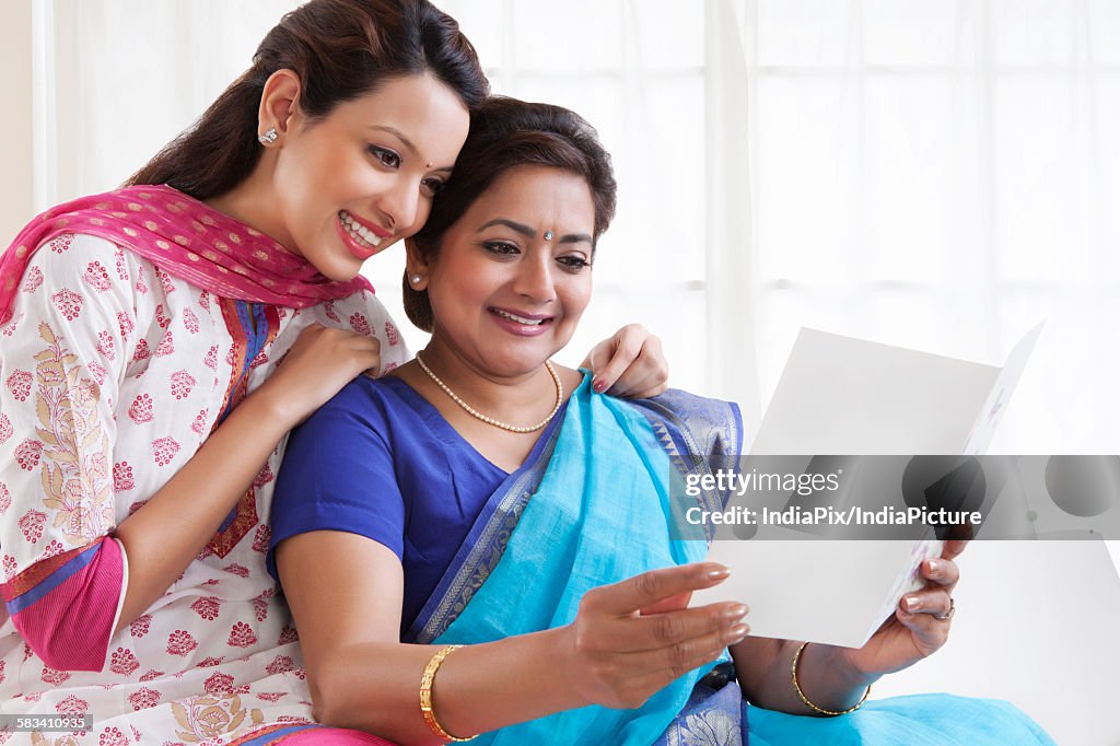 Mother and daughter reading a greeting card