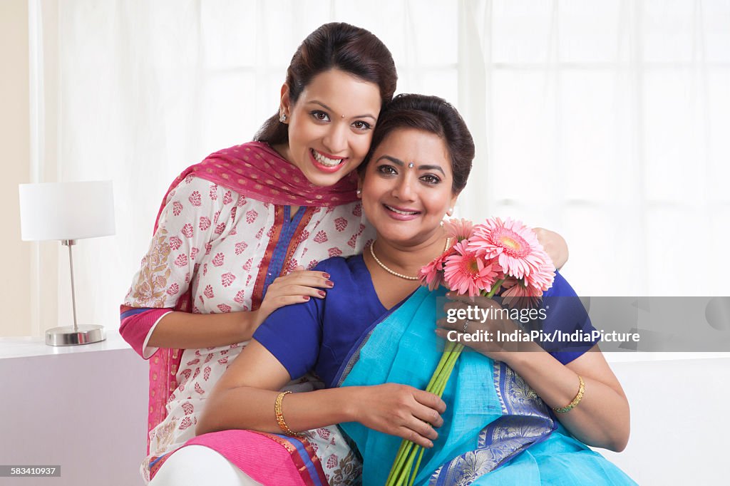 Portrait of mother and daughter with flowers