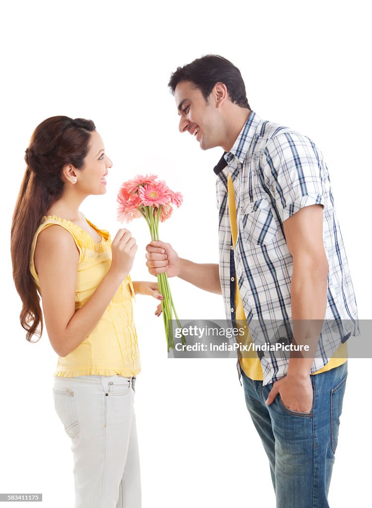 Man giving flowers to woman