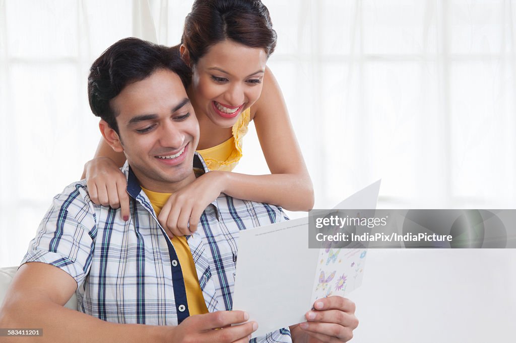 Young couple looking at a greeting card