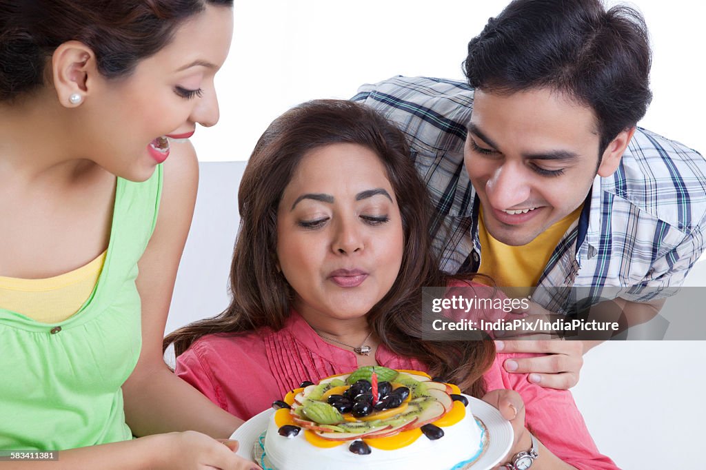 Woman blowing out candle on cake