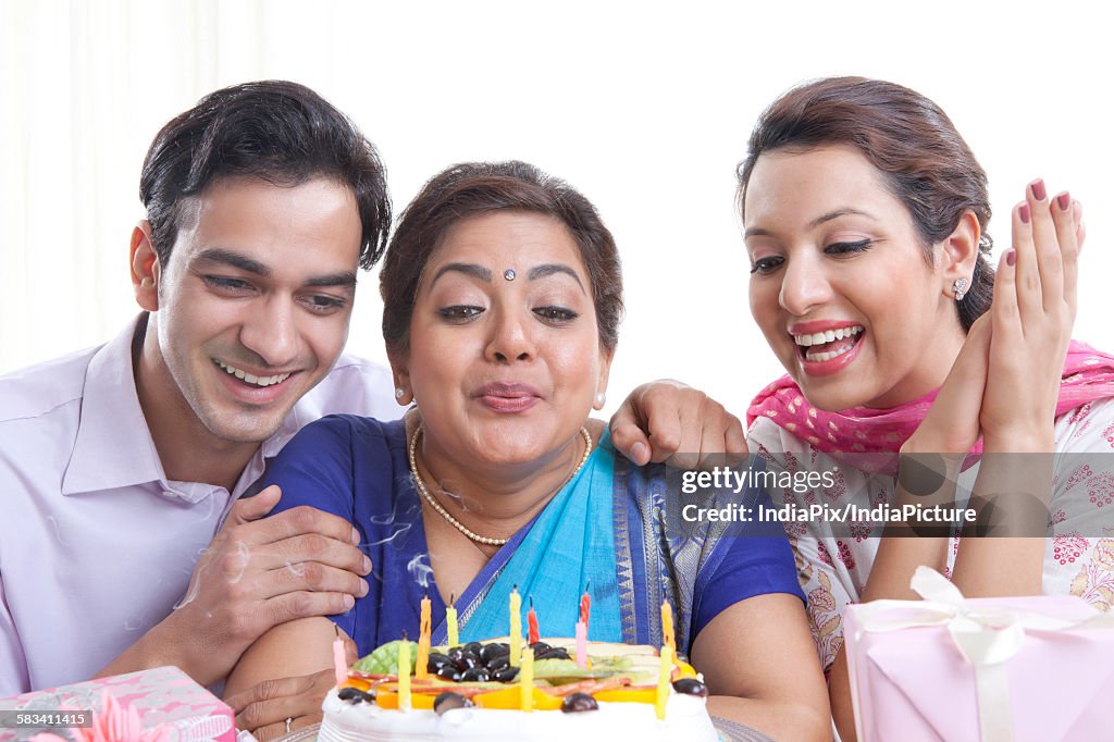 Woman blowing out candles on a birthday cake