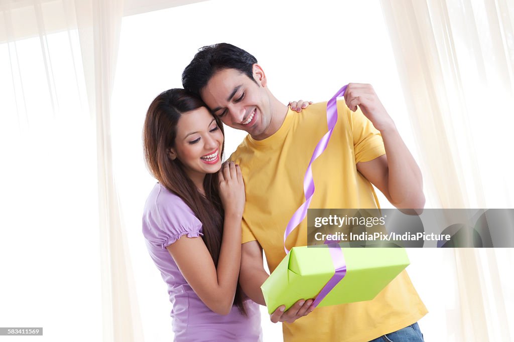 Young couple opening a gift