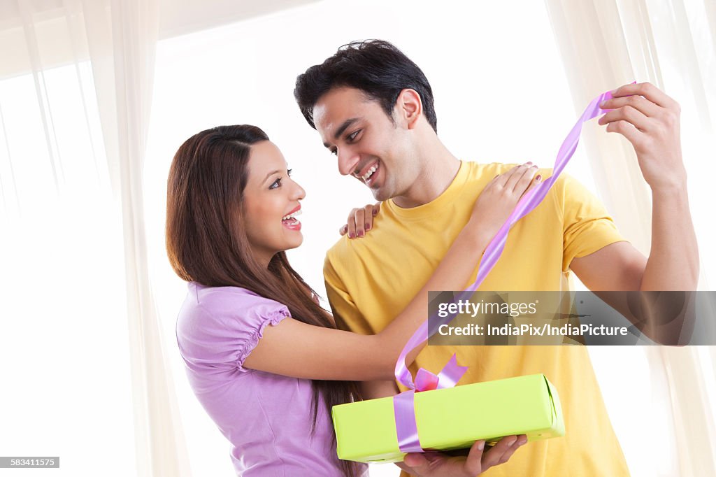 Young couple opening a gift