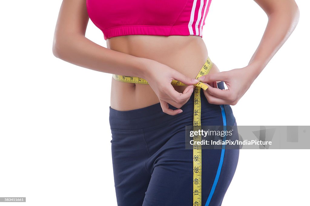 Woman measuring her waist