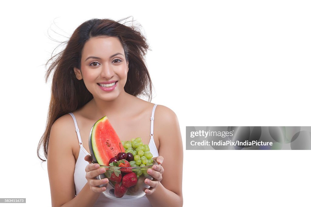 Portrait of woman with bowl of fruits