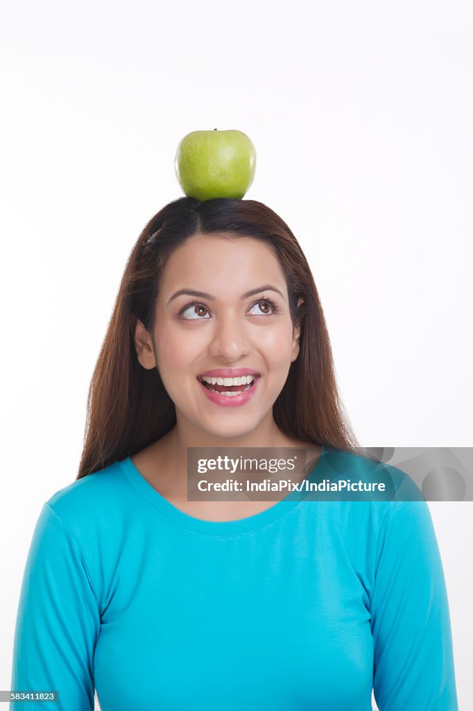 Woman balancing apple on head