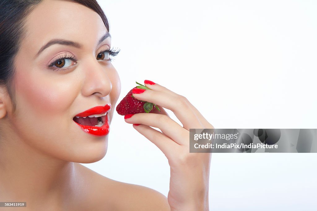 Portrait of a woman about to eat a strawberry