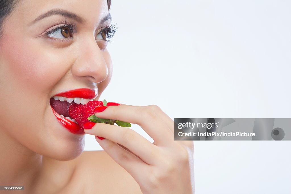 Woman eating a strawberry