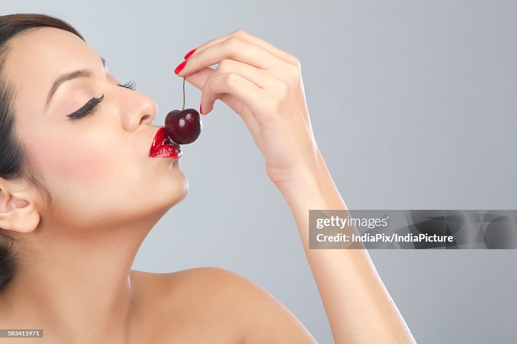 Woman kissing a cherry