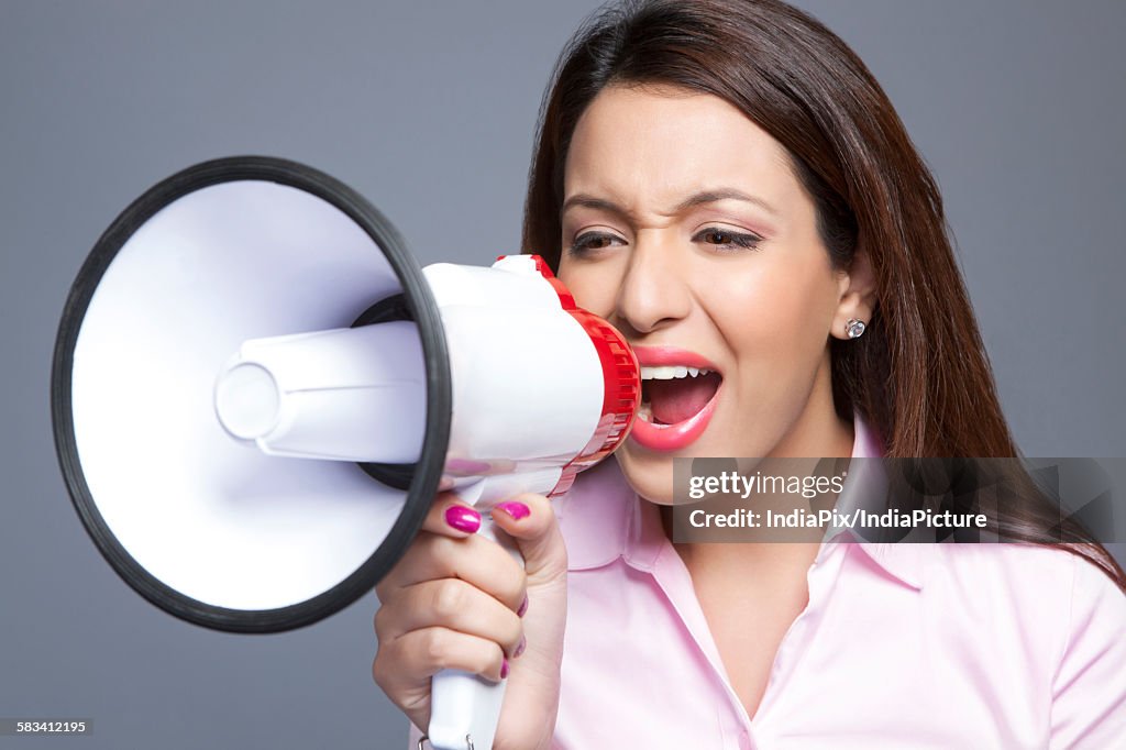 Female executive shouting through megaphone