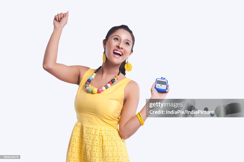 Young woman with mobile phone rejoicing