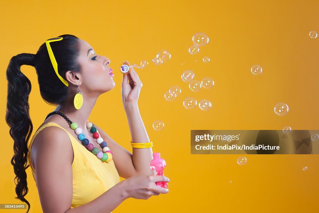 Young woman blowing bubbles