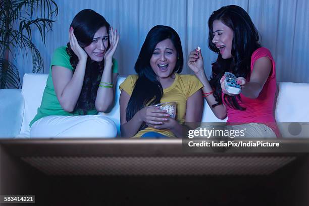 young women watching a movie - scary movie stockfoto's en -beelden