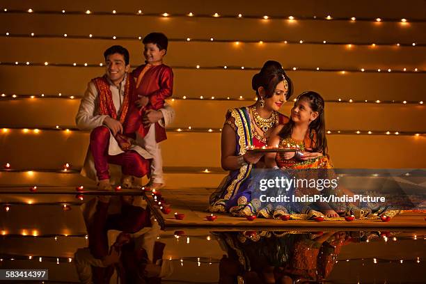 family arranging diyas - diwali family stock-fotos und bilder