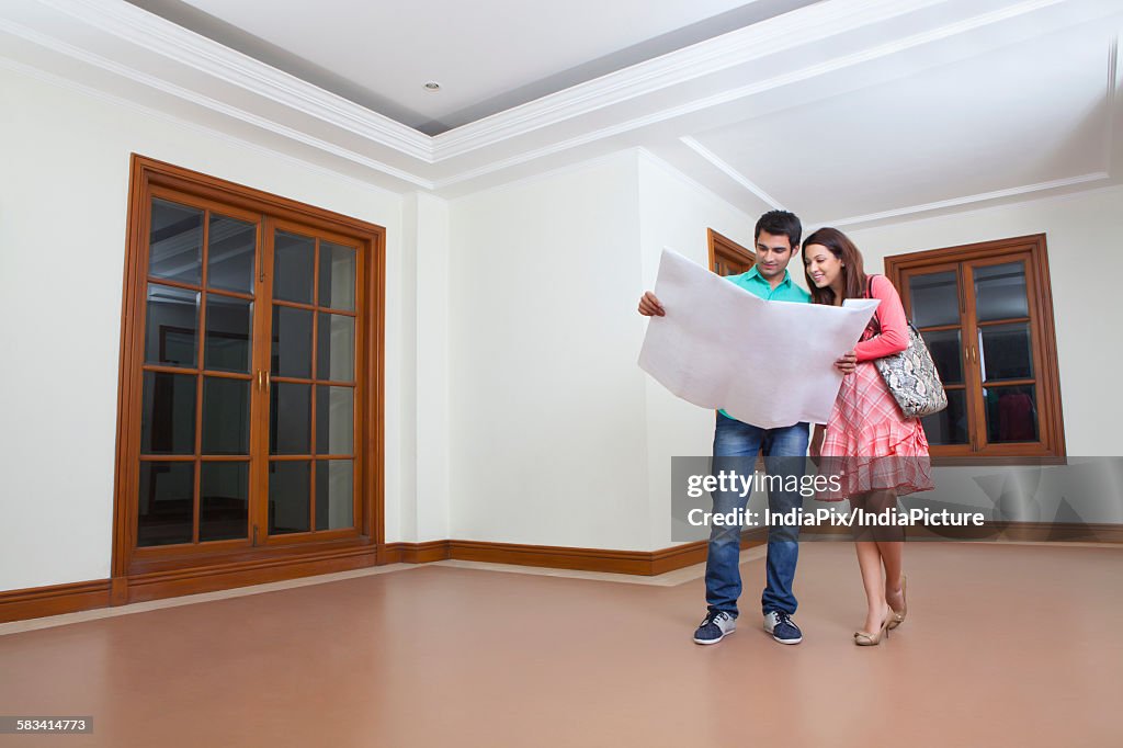 Young man and young woman looking at lay out of house