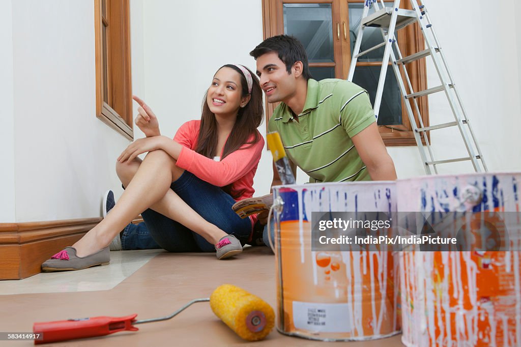 Young couple getting their house painted