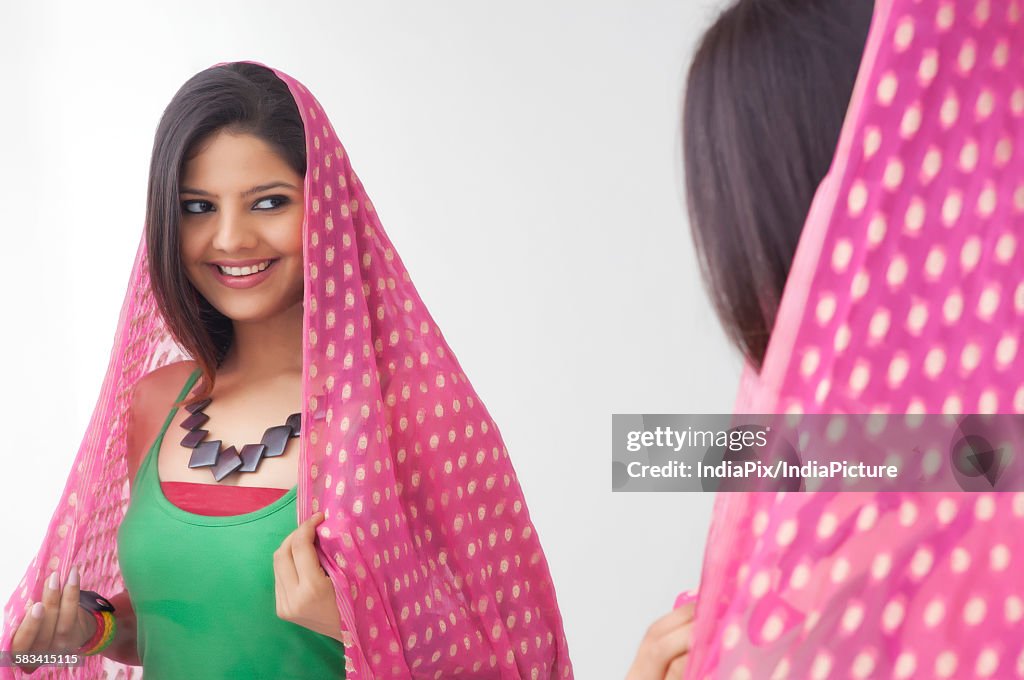 Young woman looking at herself in the mirror