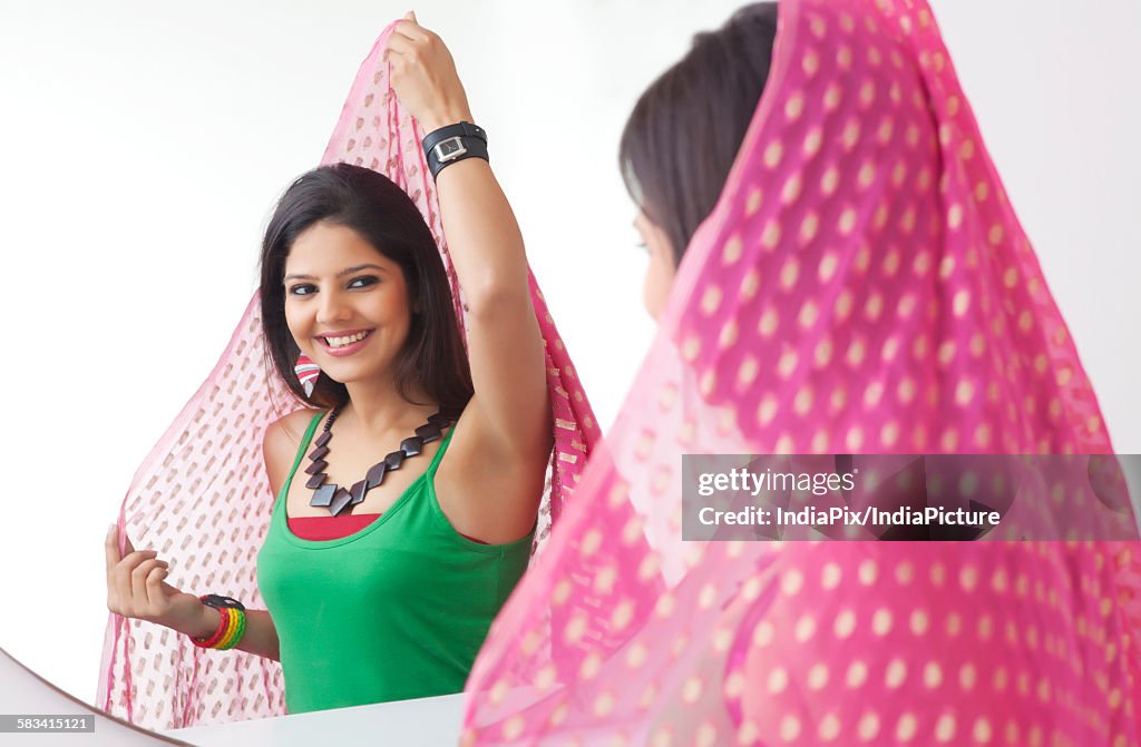 Young woman looking at herself in the mirror