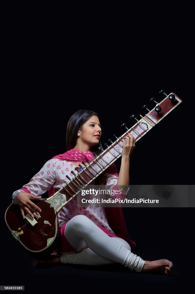 Young woman playing the sitar