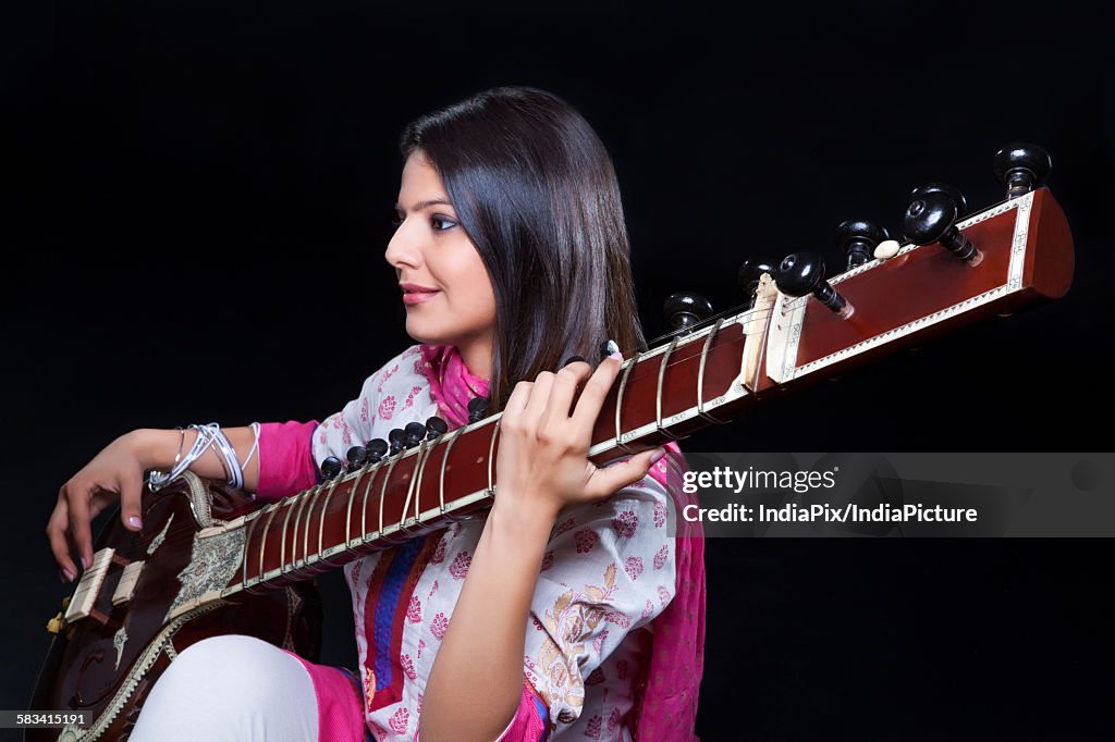 Young woman playing the sitar