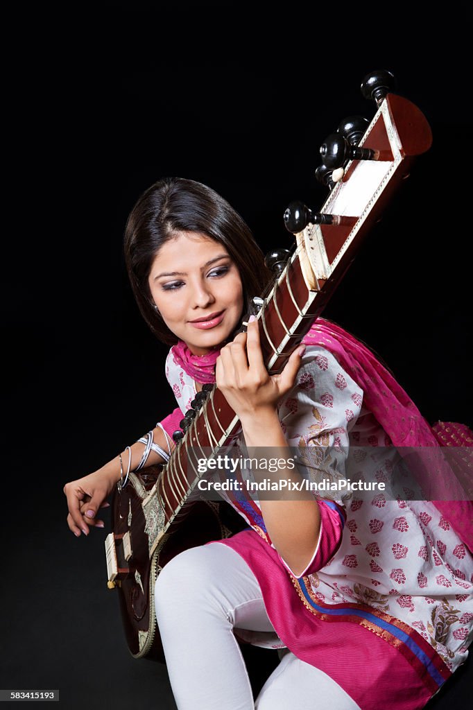 Young woman playing the sitar