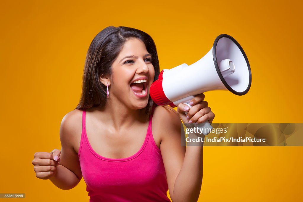 Young woman screaming into a megaphone