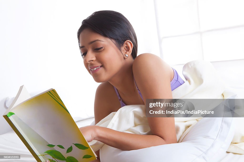 Girl reading a book in bed