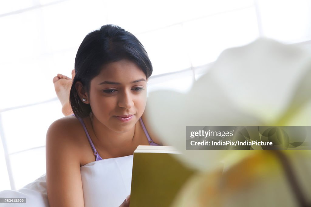 Girl reading a book in bed